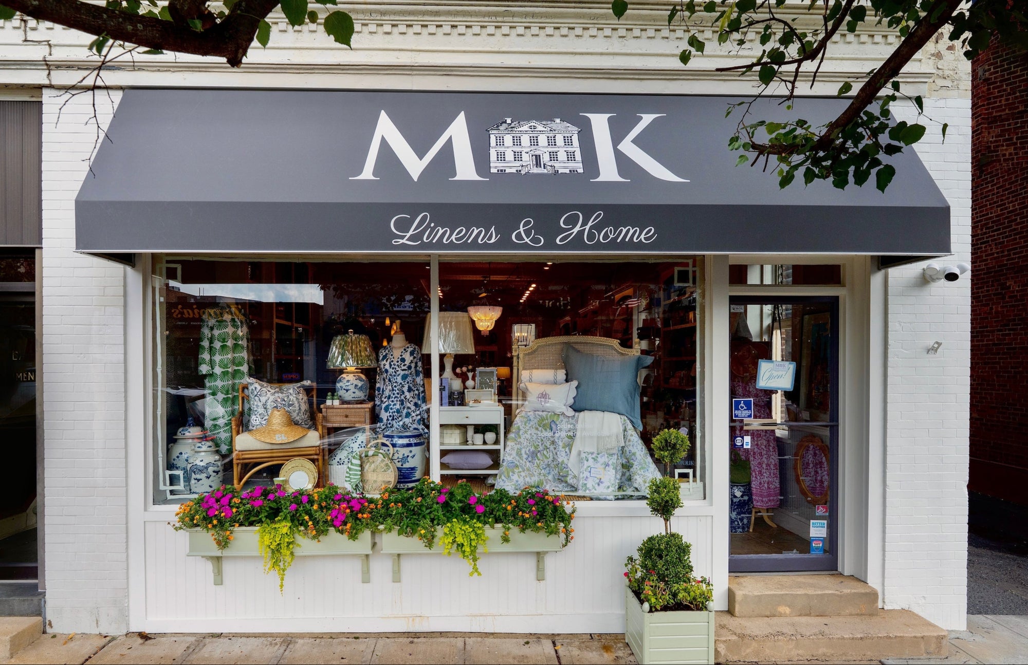 Storefront with 'MK Linens & Home' sign and display window